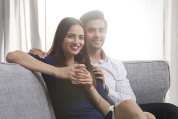Portrait of a young couple sitting on sofa