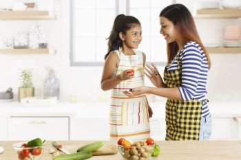 Mother and daughter cooking together in kitchen