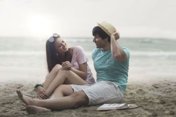Young couple sitting together on beach