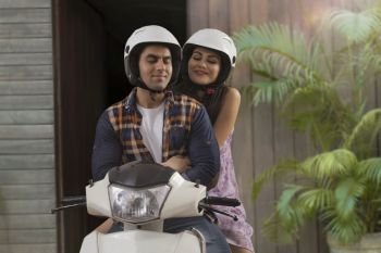Cheerful young couple sitting on a motorbike