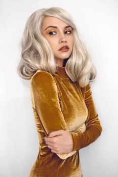 Fashion studio portrait of young beautiful blonde in brown velvet dress 