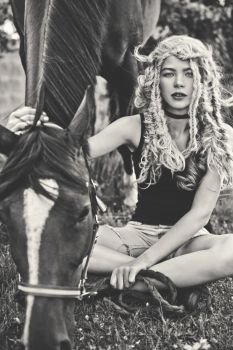 Black and white outdoor fashion portrait of beautiful young girl with horse. Hippie style. Summer vibes. Autumn season