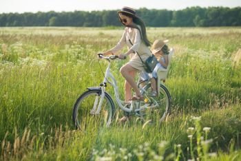 Mother and daughter have bike ride on nature. Summertime activity