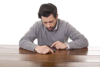 worried casual man with a phone, on a desk, isolated. on the phone