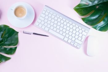 Flat lay home office workspace. Flat lay home office workspace - white modern keyboard with coffee cup on pink background