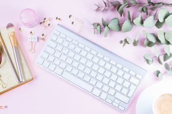 Flat lay home office workspace. Flat lay home office workspace - white modern keyboard with female accessories on pink background