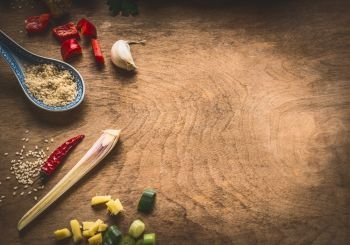 Asian cuisine spices  ingredients chopped ginger, chili, sesame seeds, garlic, on rustic wooden background, top view. Chinese or Thai food cooking concept