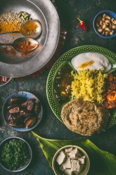 Indian food, various dinner meals in bowls on dark rustic background, top view