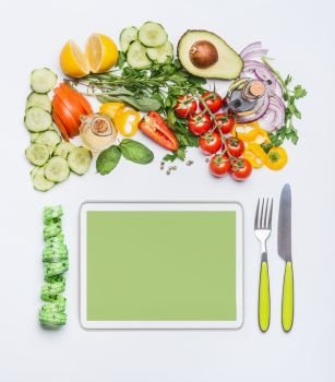 Healthy lifestyle and modern dieting concept.  Various fresh salad vegetables with cutlery and measuring tape around PC tablet . Copy space for shopping list, recipes, dieting plan or menu. Top view