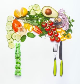 Healthy clean eating or diet food concept. Various salad vegetables cutlery and green measuring tape on white background, top view, flat lay, frame.
