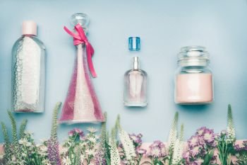 Natural cosmetic products. Jars and bottles with tonic , mist, perfume,cream ,tonic and micellar water on herbal leaves and wild flowers background, copy space for your text or branding , top view
