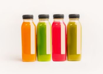 Colorful smoothie or juice bottles stand on white background, front view. Branding copy space