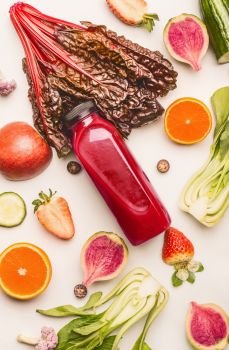 Red smoothie bottle with healthy fruits and vegetables ingredients on white desk background, top view, flat lay, vertical. Healthy clean and detox, weight loss dieting or fasting  food concept
