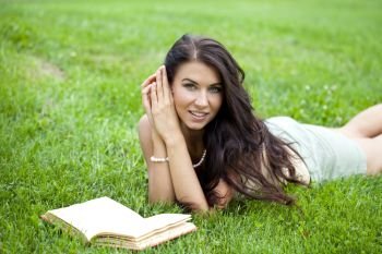 Young beautiful girl reading a book outdoor 