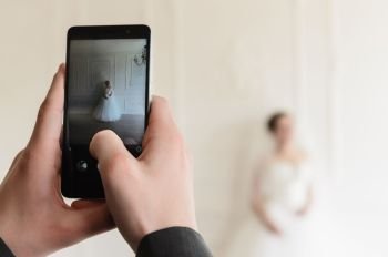 the bride groom photographs on the smartphone