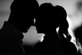 silhouettes of the young couple of the bride and groom in the backlight