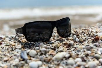 sunglasses lying in the sand on the seashore