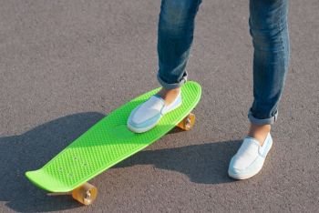 Teenager in jeans with a skateboard in the street.