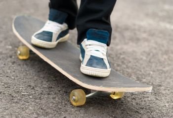Skateboarder rides on a skateboard feet in sneakers.