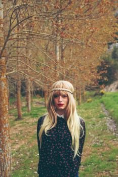 Young blonde woman lost in a forest in autumn 