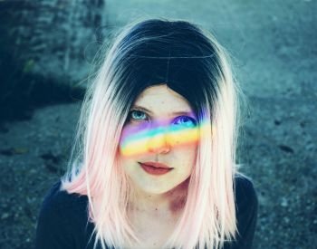 Young alternative woman with a rainbow in her face 