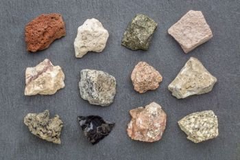 igneous rock geology collection, from top left: scoria, pumice, gabbro, tuff, rhyolite, diorite, granite, andesite, basalt, obsidian,  pegmatite, porphyry