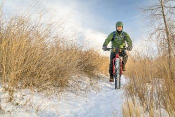 senior cyclist is riding a fat bike in winter, cold day in Colorado