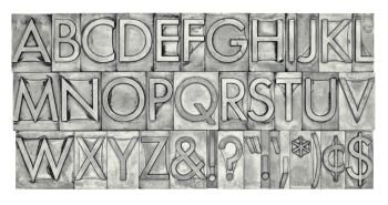 English alphabet, dollar, cent and punctuation signs in vintage metal type, black and white image with platinum toning