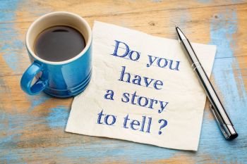 Do you have a story to tell? Handwriting on a napkin with a cup of espresso coffee
