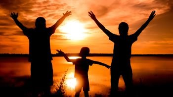 silhouette of family. Happy family standing  on the dawn time . sunset in nature