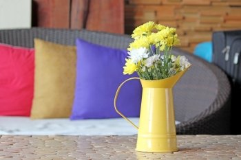 yellow and white chrysanthemum in small watering flower pot on table decorated in living room