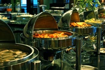 steam pans with food ready for customers on buffet table
