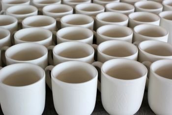 ceramic cups under production in pottery workshop
