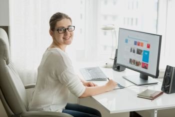 Young female designer working at home office at computer