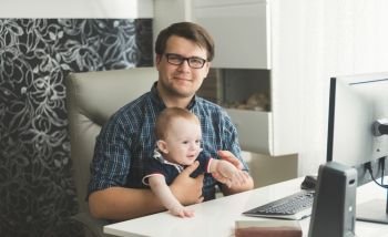 Father with his baby son working at office