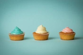 Closeup of cupcakes with colorful buttercream on blue background