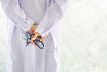 back view of doctor hand hold stethoscope with blur background and copy space