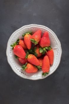 Strawberries on white ceramic bowl.