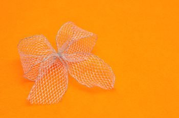 A silver bow isolated on an orange background