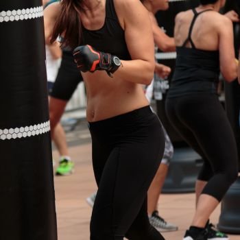 Young Girl in Black Sportswear: Fitness Boxing Workout with Punching Bag