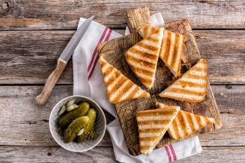hot toasted sandwich panini with ham and cheese on wooden cutting board