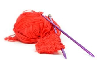 Knitting wool and knitting needles on white background