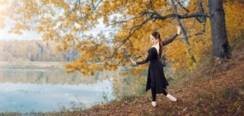 Modern ballet dancer in the autumn park by the lake. Freedom, harmony and unity with nature.