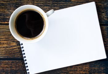 hot coffee in cup and paper for note