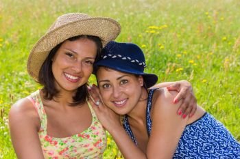 Woman with hat holding  friend in blooming meadow