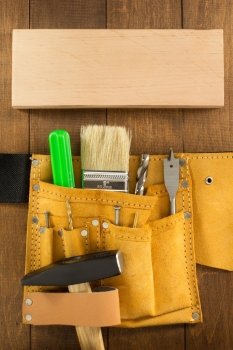 tools and instruments in belt on wood. tools and instruments in belt on wooden background