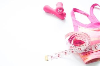 Workout and Healthy lifestyle concept with pink color sport bra, sport equipment and measuring-tape