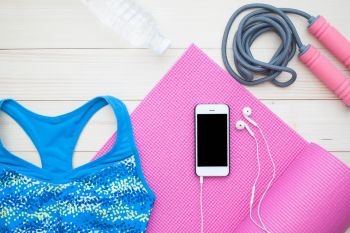 Overhead view of Fitness items for woman. Diet and Workout concept, smart phone on yoga mat for sport application mock up