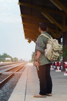 Traveler man waiting  with backpack in train station. Travel concept.
