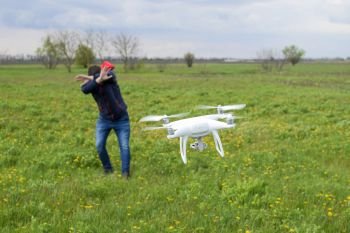 A man hides himself from a collision with a drone. Quadrocopter flies to the person.. A man hides himself from a collision with a drone. Quadrocopter flies to the person